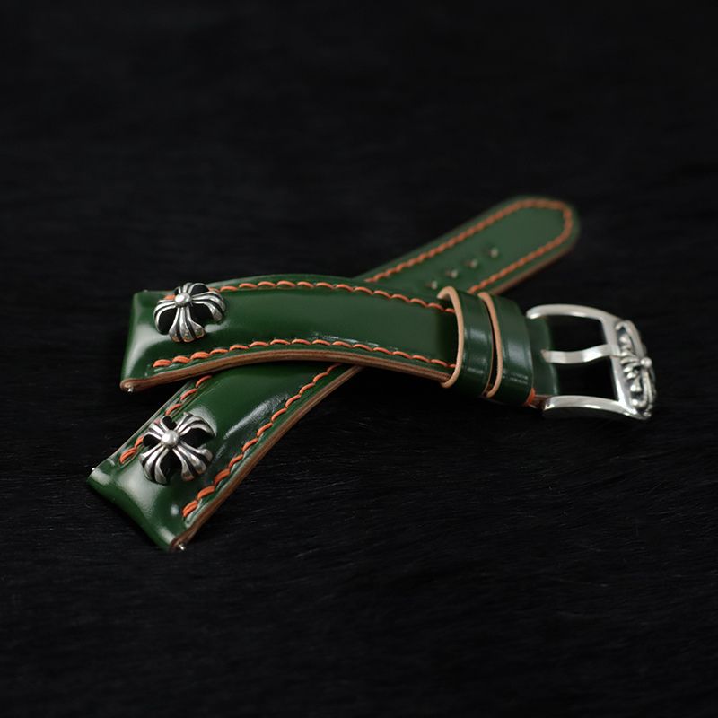 Handcrafted green Shell Cordovan leather watch strap featuring cross studs and sterling silver accents, designed for premium watches